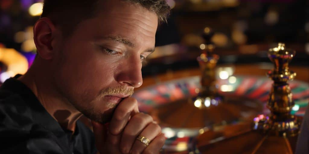 Sports bettor observing a blurred roulette wheel.