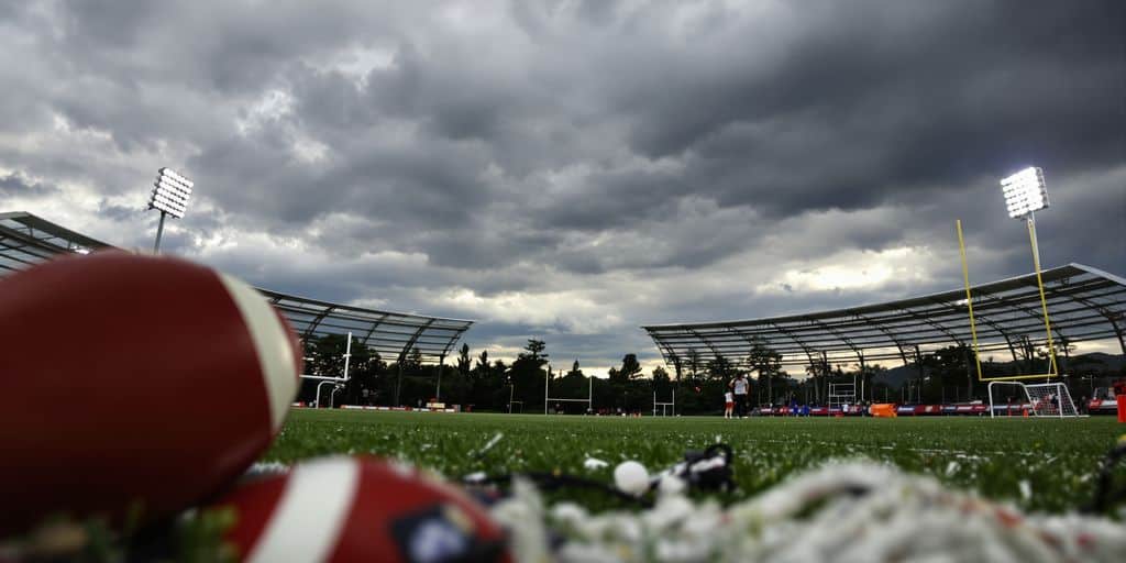 Sports field under stormy skies with betting odds.